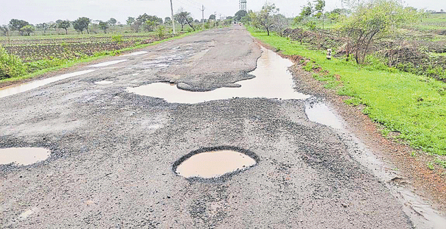 బెంగళూరులో గుంతల రోడ్డుపై ట్రక్కు బోల్తా: నగర మౌలిక సదుపాయాల సంక్షోభాన్ని హైలైట్ చేస్తుంది||Truck Overturns on Cratered Road in Bengaluru: Highlights City's Mounting Infra Crisis