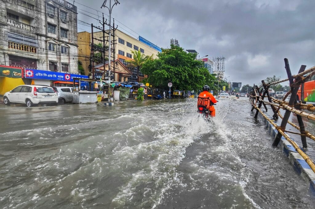 Current image: A motorcyclist rides through waterlogged streets in Kolkata during the monsoon season.