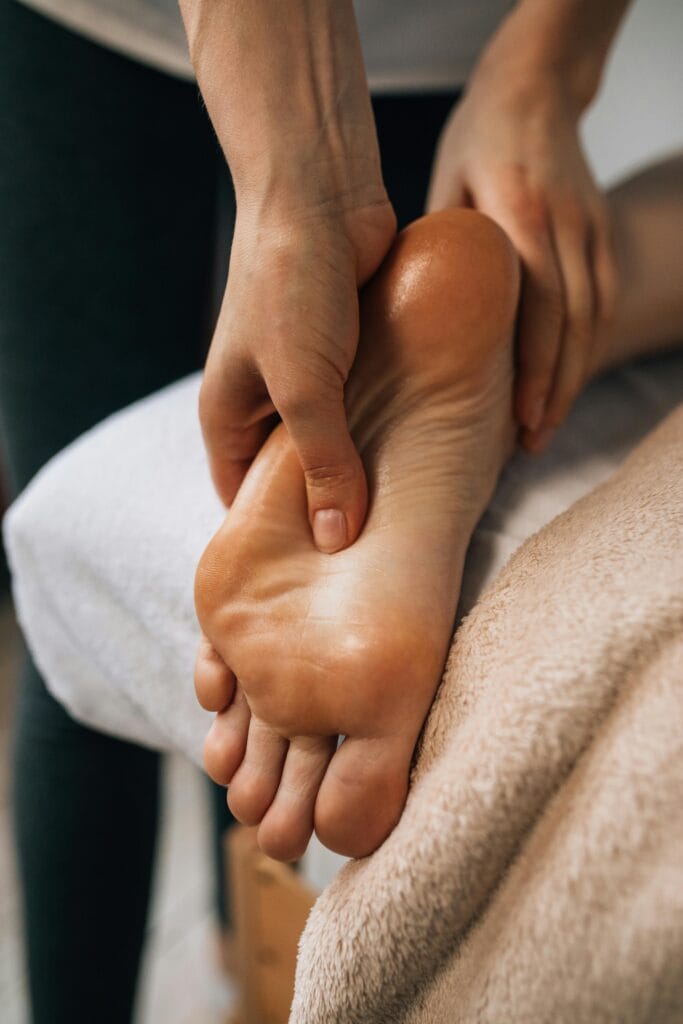 Current image: Hands massaging a foot to provide relaxation and promote wellness indoors.