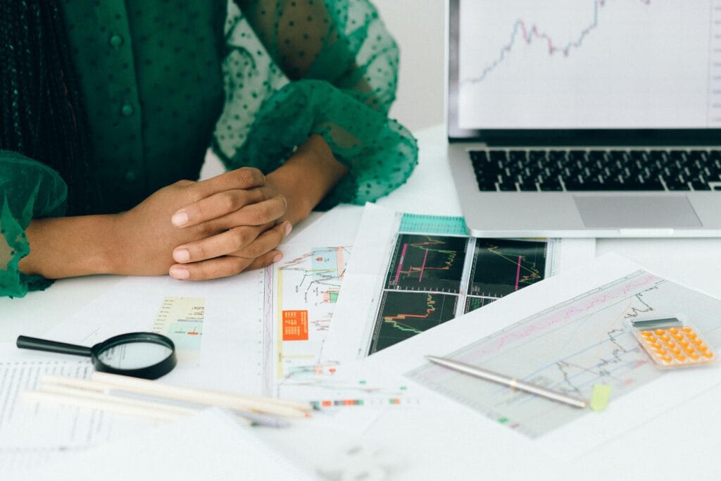 Current image: A person analyzes financial charts and graphs at a desk, indicating business trading activity.