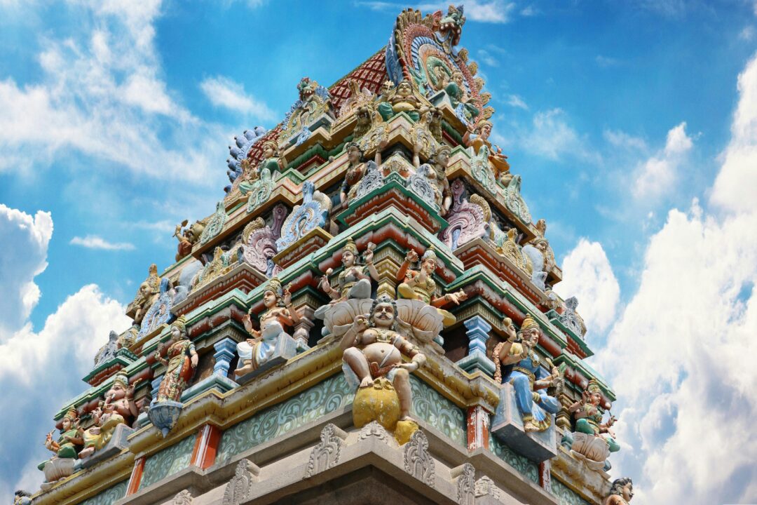 Current image: Vibrant gopuram of a Hindu temple in Salem, India, showcasing intricate designs under a blue sky.